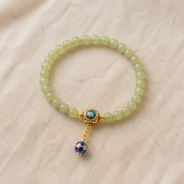 Serene Path pale green beaded bracelet with blue-and-gold charm - product-only view