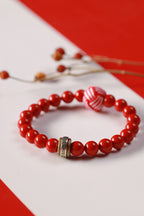 Cinnabar beaded bracelet: full view with engraved metal ring and red-and-white woven bead